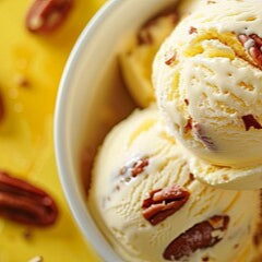 Ice cream with pecans in a bowl on a yellow background